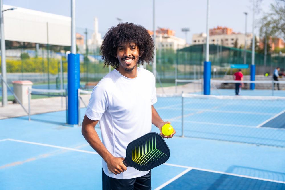 A young man playing Pickleball on a resurfaced Pickleball Court installed by Coastal Courts in Orlando